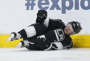 Los Angeles Kings right wing Kris Versteeg slides into the boards with an injury before being helped off the ice against the Boston Bruins during the third period of an NHL hockey game, Saturday, March 19, 2016, in Los Angeles. (AP Photo/Danny Moloshok)