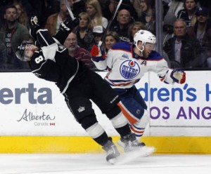 Edmonton Oilers left wing Taylor Hall, right, knocks back Los Angeles Kings defenseman Drew Doughty in pursuit of the puck during the first period of an NHL hockey game in Los Angeles, Saturday, March 26, 2016. (AP Photo/Alex Gallardo)